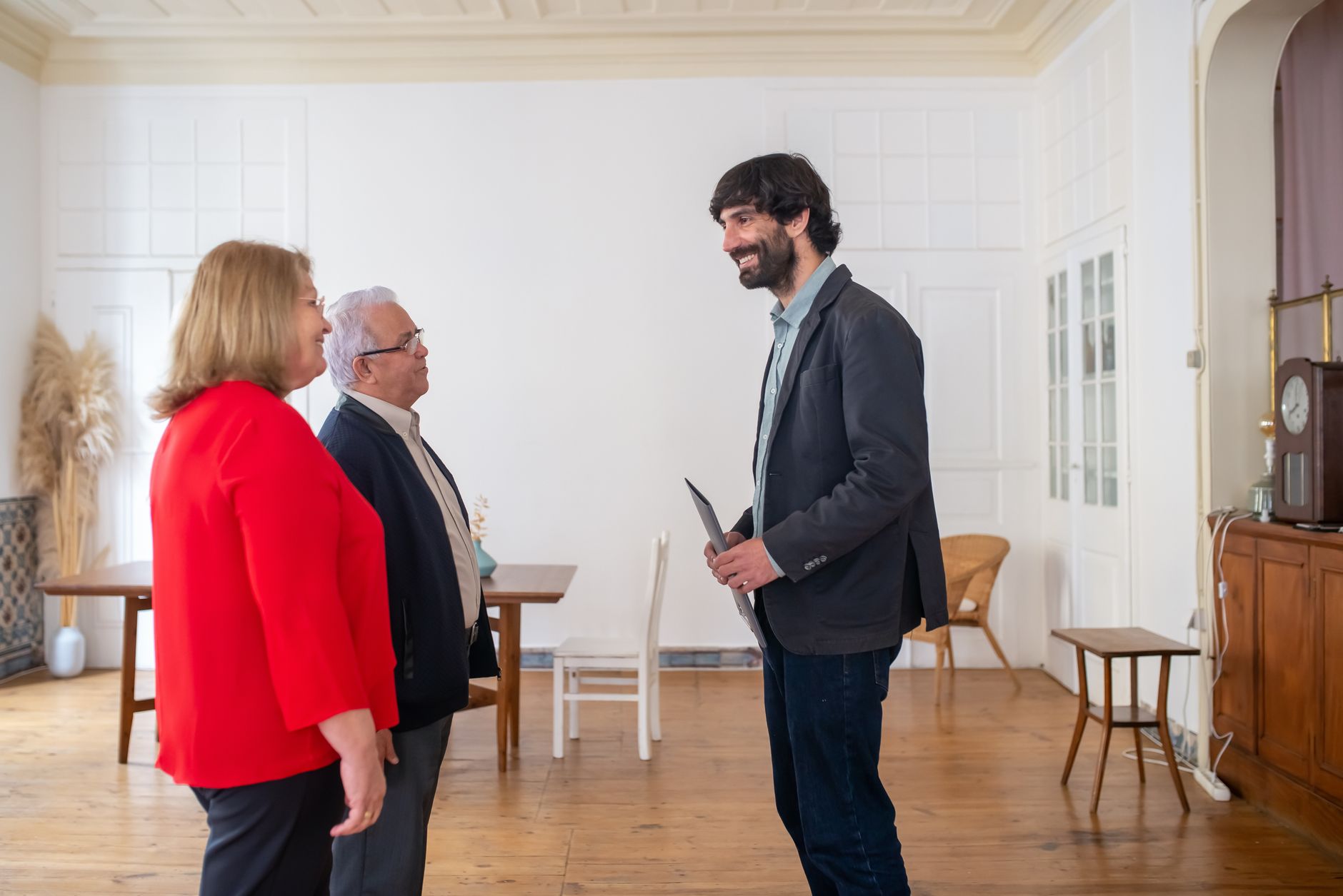 A community representative listening to two older residents